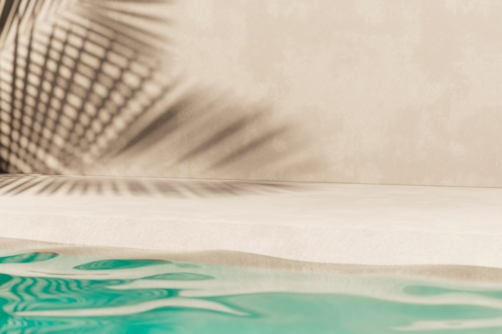 Pool Resurfacing 2 Tropical summer background with concrete wall, pool water and palm leaf shadow.